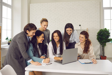 Group of happy young women having fun while working on business project together