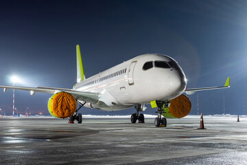 Modern passenger airliner on the night airport apron