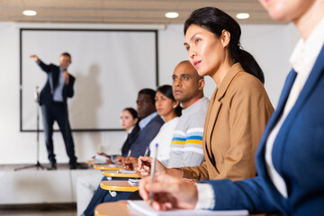 Portrait of asian woman attending business training, listening with interest to speaker