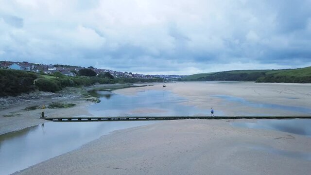 Man Crossing Bridge Across Gannel River In Newquay United Kingdom - Wide shot