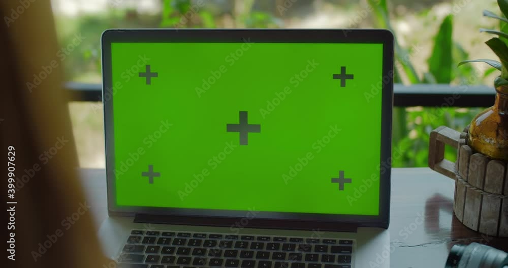 Poster laptop with green screen close up on the table person typing on keyboard