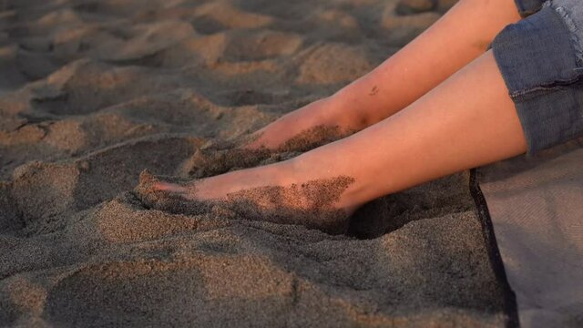 girl putting her feet in the sand on beach