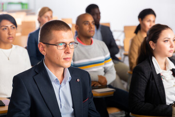 Fototapeta premium Portrait of focused businessman attending business conference, listening with interest to speaker