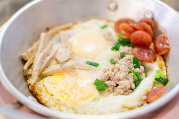 Breakfast with fried eggs in a pan with bacon and vegetables