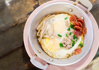 Breakfast with fried eggs in a pan with bacon and vegetables