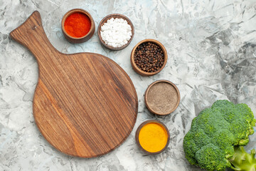 Fototapeta na wymiar Horizontal view of healthy wooden cutting board different spices and broccoli on white background