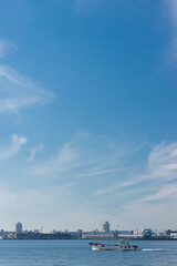 青空と名古屋港の海面で航海中の船の様子