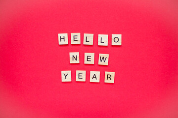 Fototapeta na wymiar Hello new year. The inscription from wooden blocks on a bright red background. New Year. Christmas.