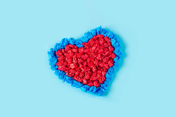 Concept of DIY and kid's creativity. Step by step instruction: make  heart. Step 5 finished craft heart from red and blue crumpled colored paper. Valentine's Day craft. Fine motor skills