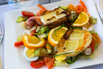 Salad from goat cheese with honey and orrange at plate, dish of french cuisine