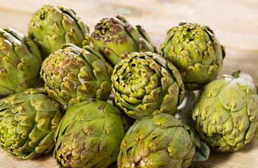 Fototapeta premium Fresh ripe artichokes on wooden background