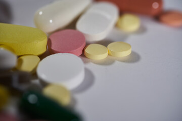 Colored pills, tablets and capsules on a white background. macro photography