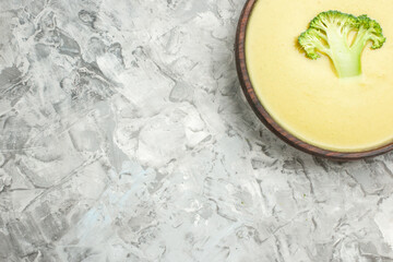 Half shot of cream of broccoli soup in a brown plate on white background horizontal view