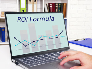 Business concept about Return on Investment ROI Formula with inscription on the sheet.