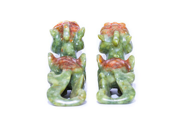 Rear view of a pair of Chinese pixiu Feng Shui statues with colourful jade on white background.