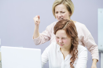 Mom swung at the teenager's daughter while the teenager ignoring mom sits in the laptop. Problems in the relationship of parents with teenage children. Pobertat, the difficulties of growing up