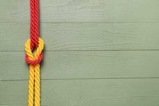 Rope with knot on wooden background