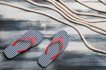 Ropes and flip flops on wooden background