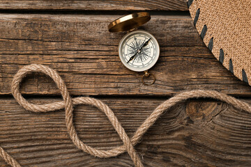 Fototapeta na wymiar Rope and vintage compass on wooden background
