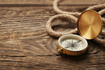 Vintage compass and rope on wooden background
