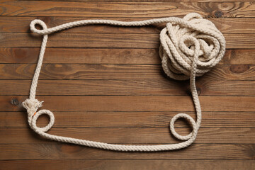Frame made of rope on wooden background