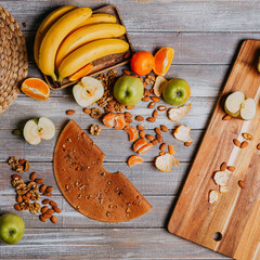 Grape fruit leather with nuts on the wooden table. Round fruit leather. Healthy food. Apples, bananas, grape top view. Grape fruit without sugar.