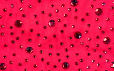 Pink knitted fabric with many rhinestones pattern. Fashion cloth background texture