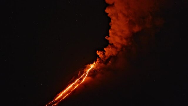 Night timelapse of Klyuchevskaya Sopka or Klyuchevskoy volcano eruption on Kamchatka. Smoke and burning lava erupting from vent. Stars sparkling on sky. Concept of wild nature and geology.