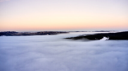 Fototapeta na wymiar Arial: Photo shot with a drone. Fog in the valley below. Norway, Oslo, Holmenkollen.