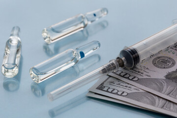 Three ampullas, expendable syringe for vaccination and paper money. Coronavirus vaccination concept. The concept of insurance medicine
