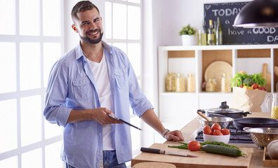Smiling and confident chef standing in large kitchen