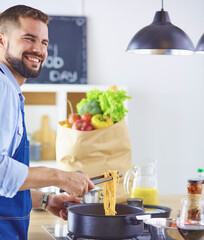 Smiling and confident chef standing in large kitchen