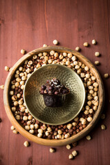 Haselnuss Muffin in Gold Messing Metall und Holz Schale mit Nüsse auf Holz Tisch Hintergrund