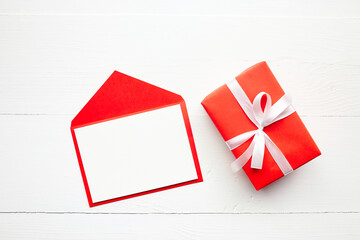 Greeting card mockup, white blank card with paper envelope, gift box with ribbon