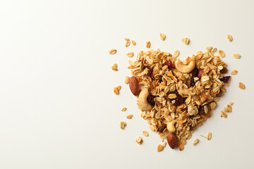 Heart made of granola on white background, top view