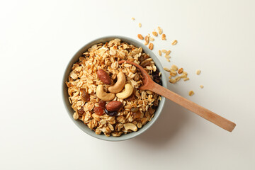 Bowl and spoon with tasty granola on white background