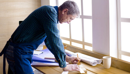 Engineer carpenter working on laptop and sketching project