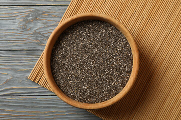 Bowl with chia seeds on wooden background