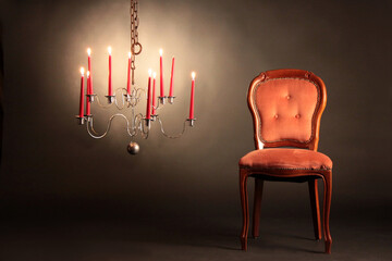 Ein leerer Stuhl neben Kandelaber mit Kerzenlicht
