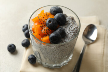 Glass with delicious chia pudding on white table