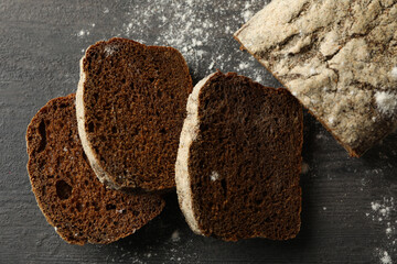 Fresh baked rye bread and flour on black background