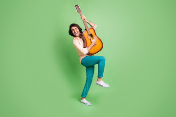 Fototapeta na wymiar Full length body size view of attractive funky cheerful guy music lover having fun playing guitar isolated over bright green color background