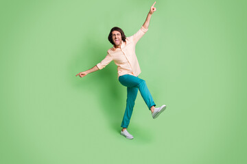 Fototapeta na wymiar Full length body size view of crazy cheerful overjoyed guy dancing having fun enjoying event isolated over bright green color background