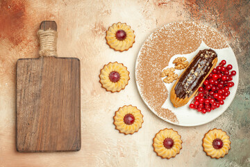 top view yummy eclair with red berries on light desk sweet cake dessert