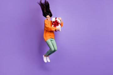 Full length body size photo of woman embracing birthday present jumping high isolated on vivid violet color background
