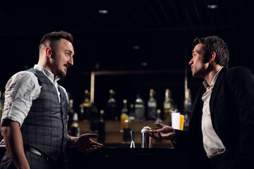 two male friends meet at the bar at the counter and communicate.