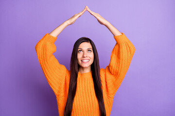 Fototapeta na wymiar Photo portrait woman wearing orange sweater showing roof over head looking up isolated bright violet color background