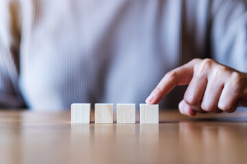 Closeup image of a hand choosing and picking a blank wooden cube block