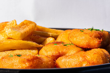 plate of chicken nuggets with french fries on dark background, close up