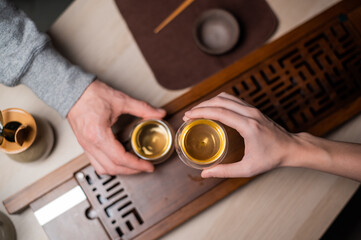 Fototapeta na wymiar Romantic date in a tea house. A man and a woman drink tea at a table with bamboo tea accessories. The view from the top